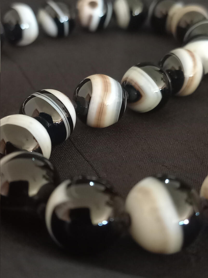 Striped onyx bead necklace with sterling silver fittings, made using traditional knotting method. Striped onyx bead necklace with sterling silver fittings, made using traditional knotting method.